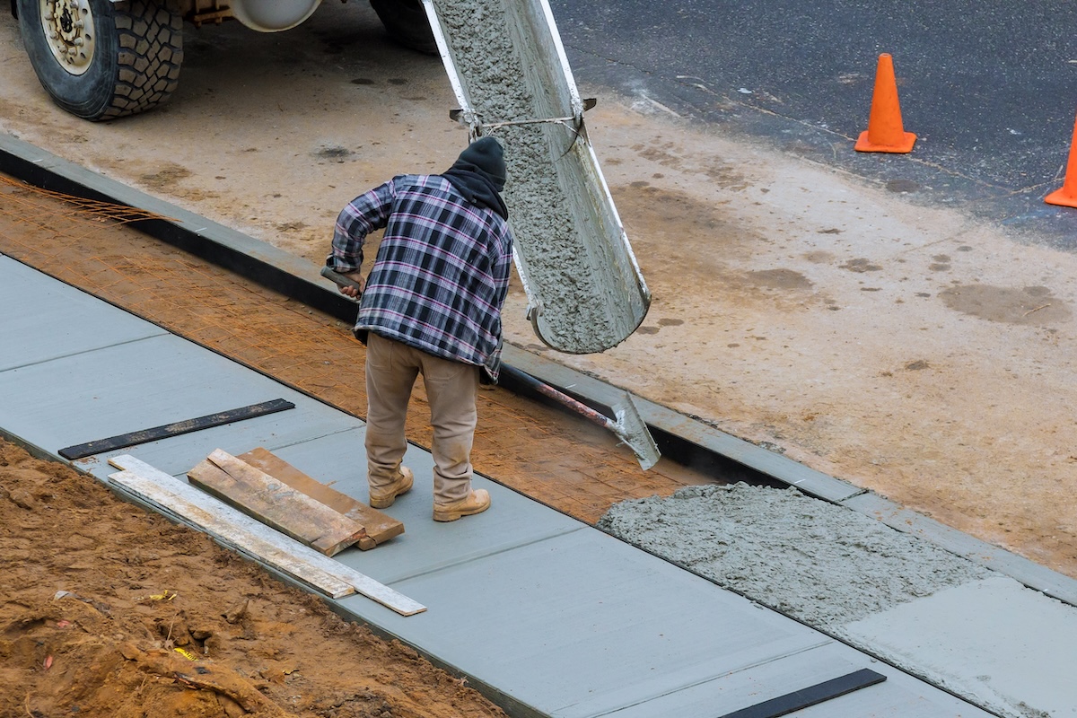 worker laying concrete walkway worker laying concrete walkway